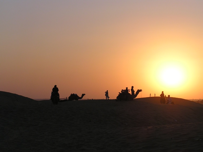 Sun sets beyond the dunes at Sam desert