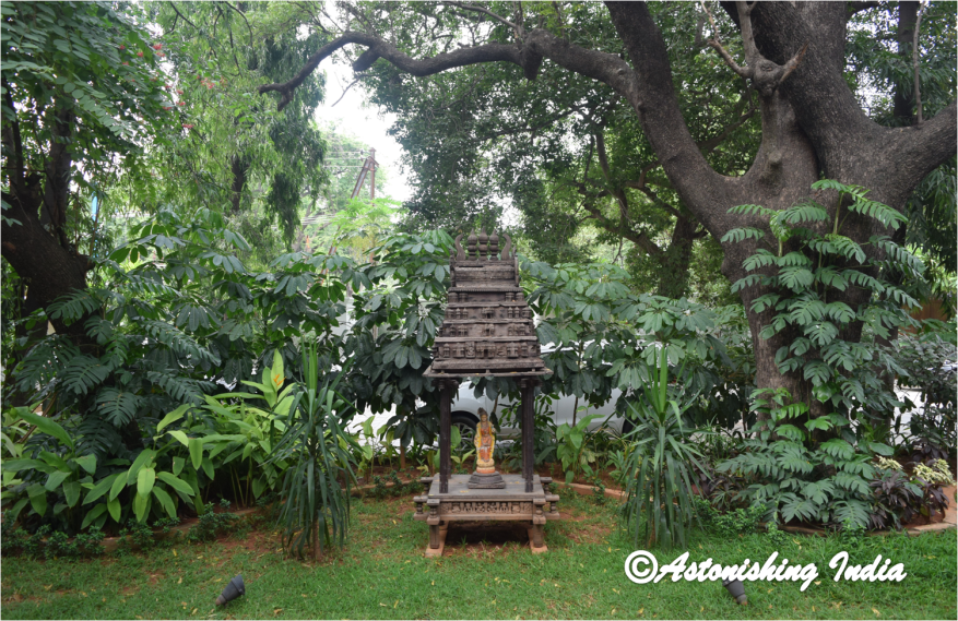 An antique wooden temple replica graces the garden